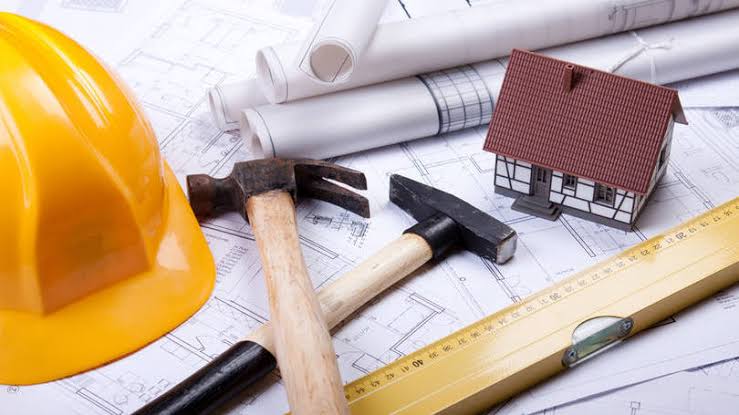 Trabalhadores da construção civil em obra ao entardecer