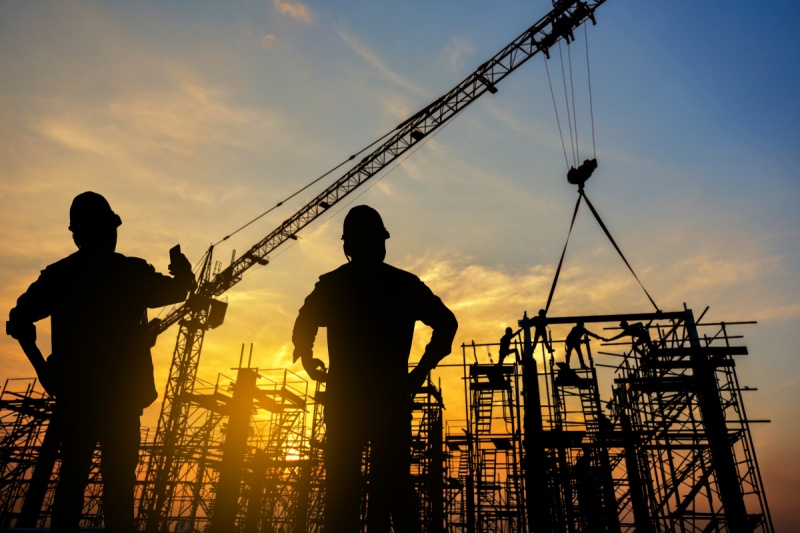 Dois profissionais de engenharia analisando uma estrutura em obra